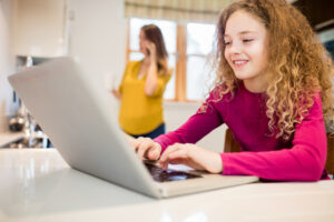 dziewczynka pisząca na klawiaturze laptopa